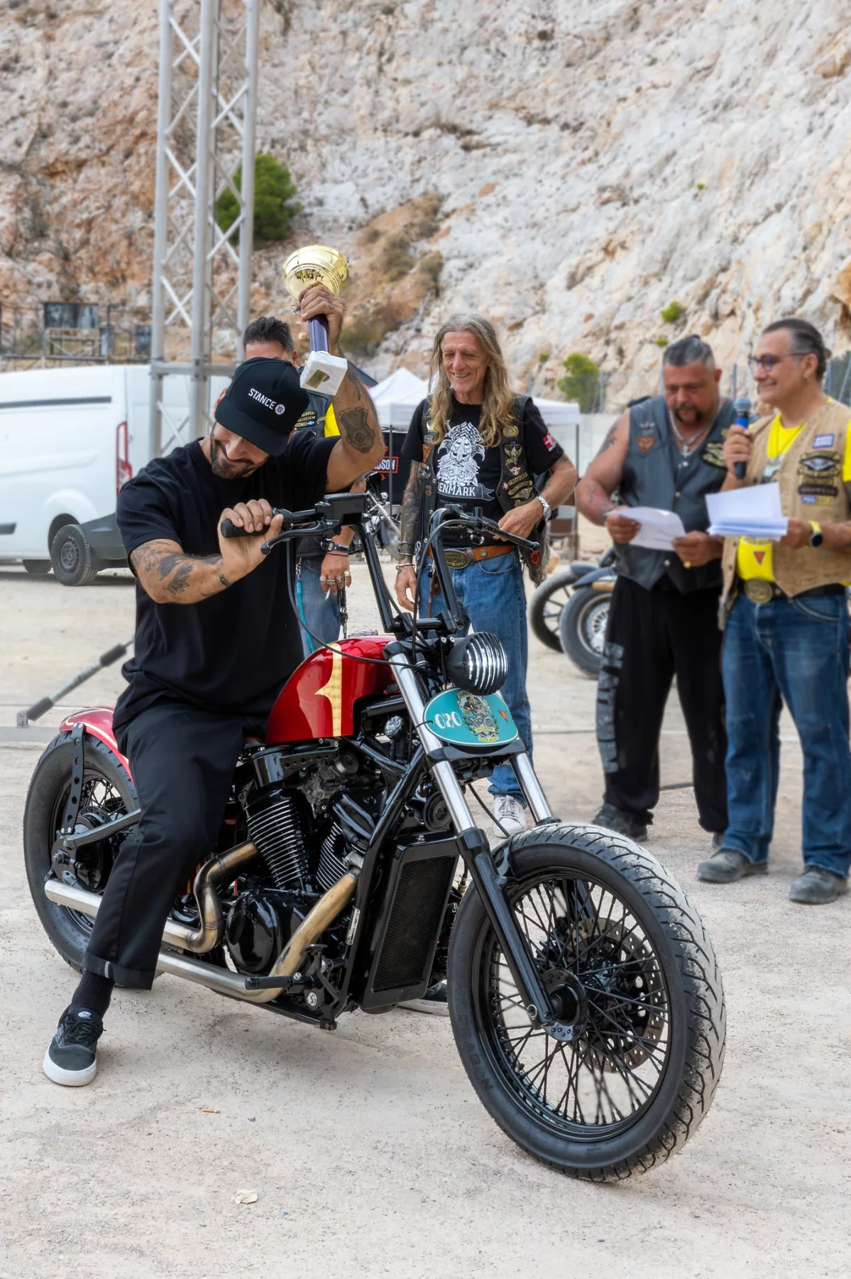 Participant holding a trophy while sitting on a custom motorcycle